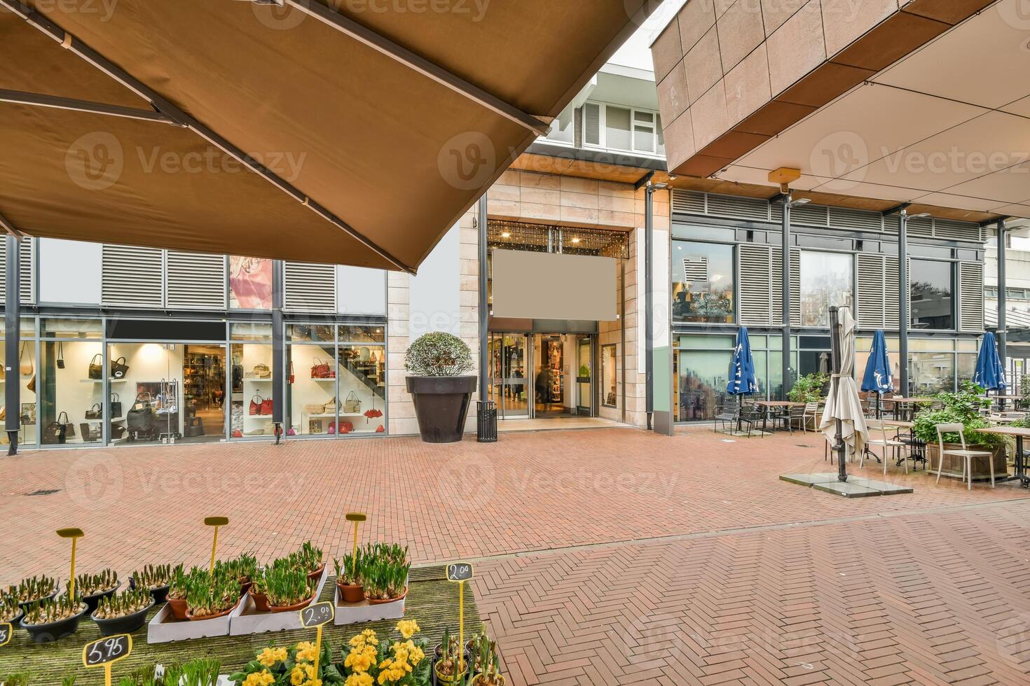 A large shopping center with a patio area and a large umbrella photo