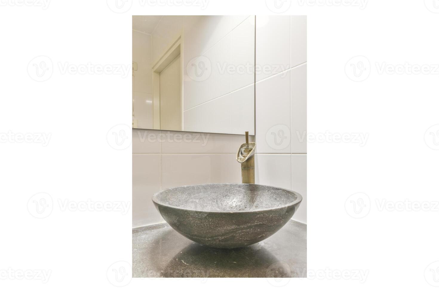 A bathroom sink with a stone bowl and a faucet photo
