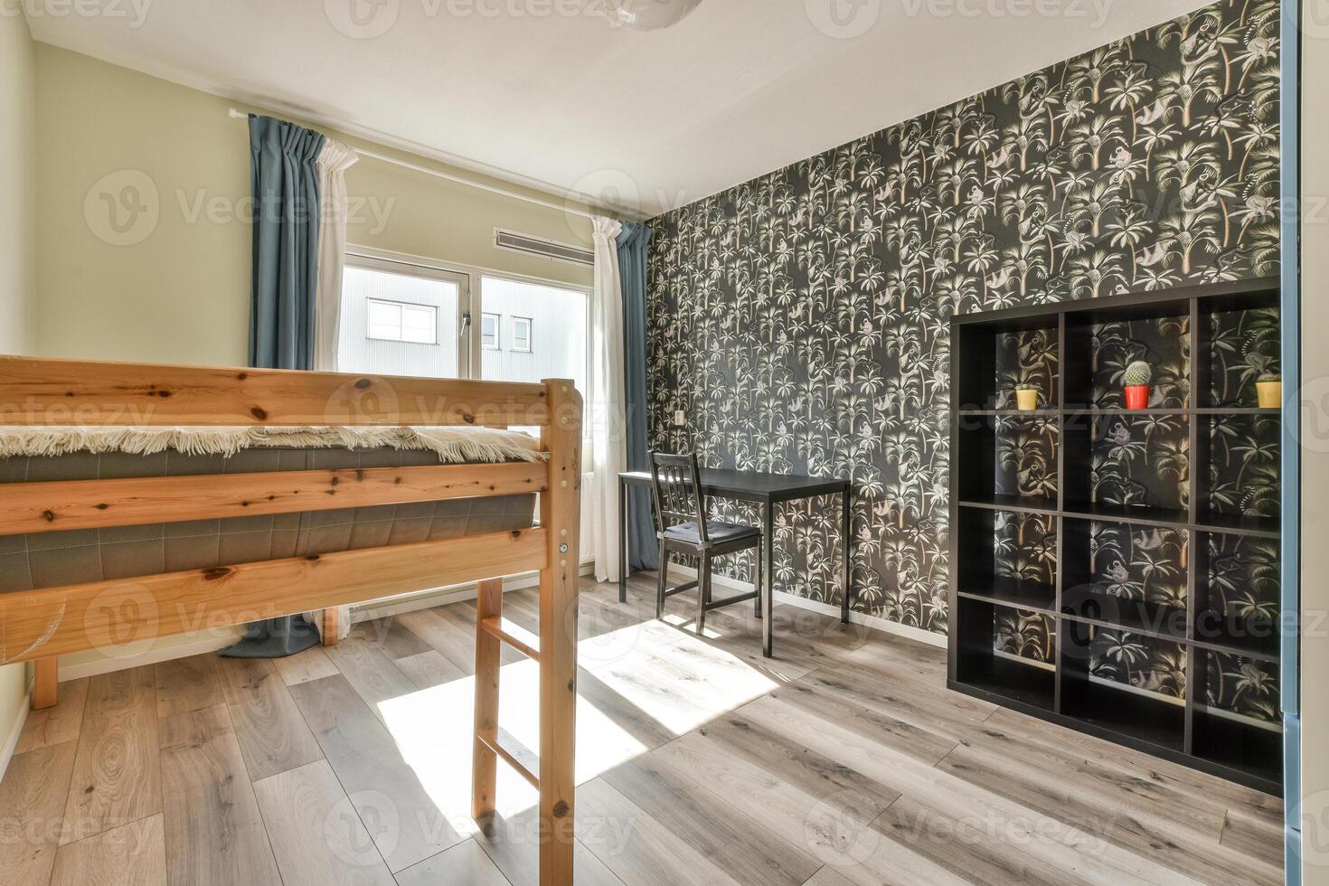 A bunk bed and desk in a room with wallpaper photo