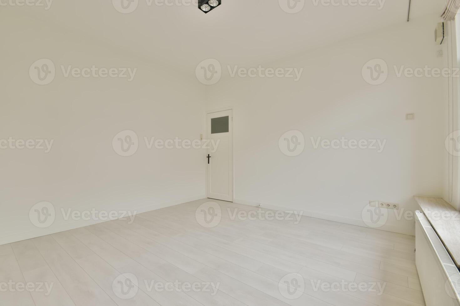 An empty room with white walls and wooden floors photo
