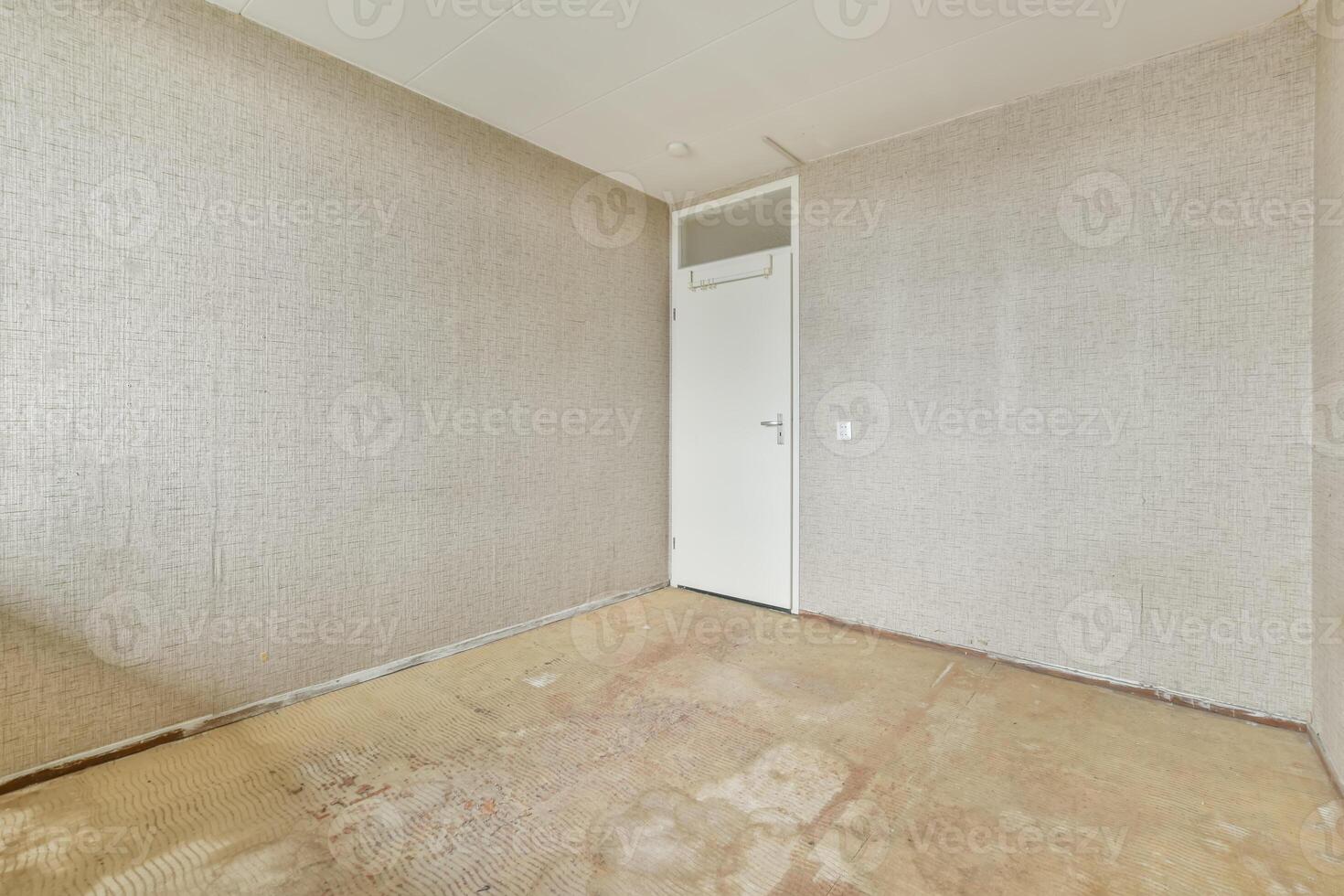 An empty room with a door and a wall photo