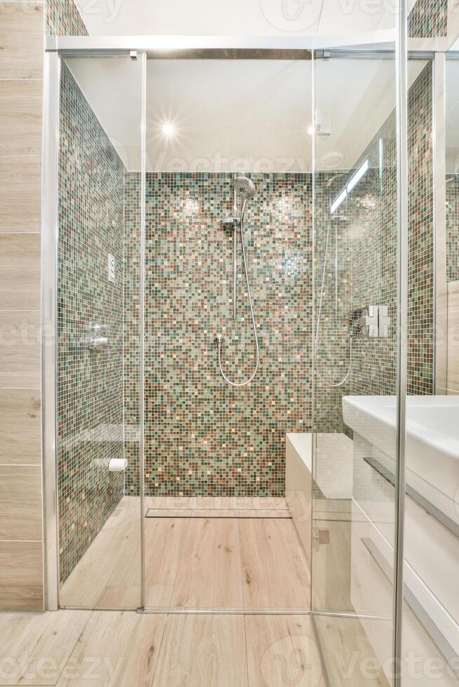 A bathroom with a glass shower door and a toilet photo