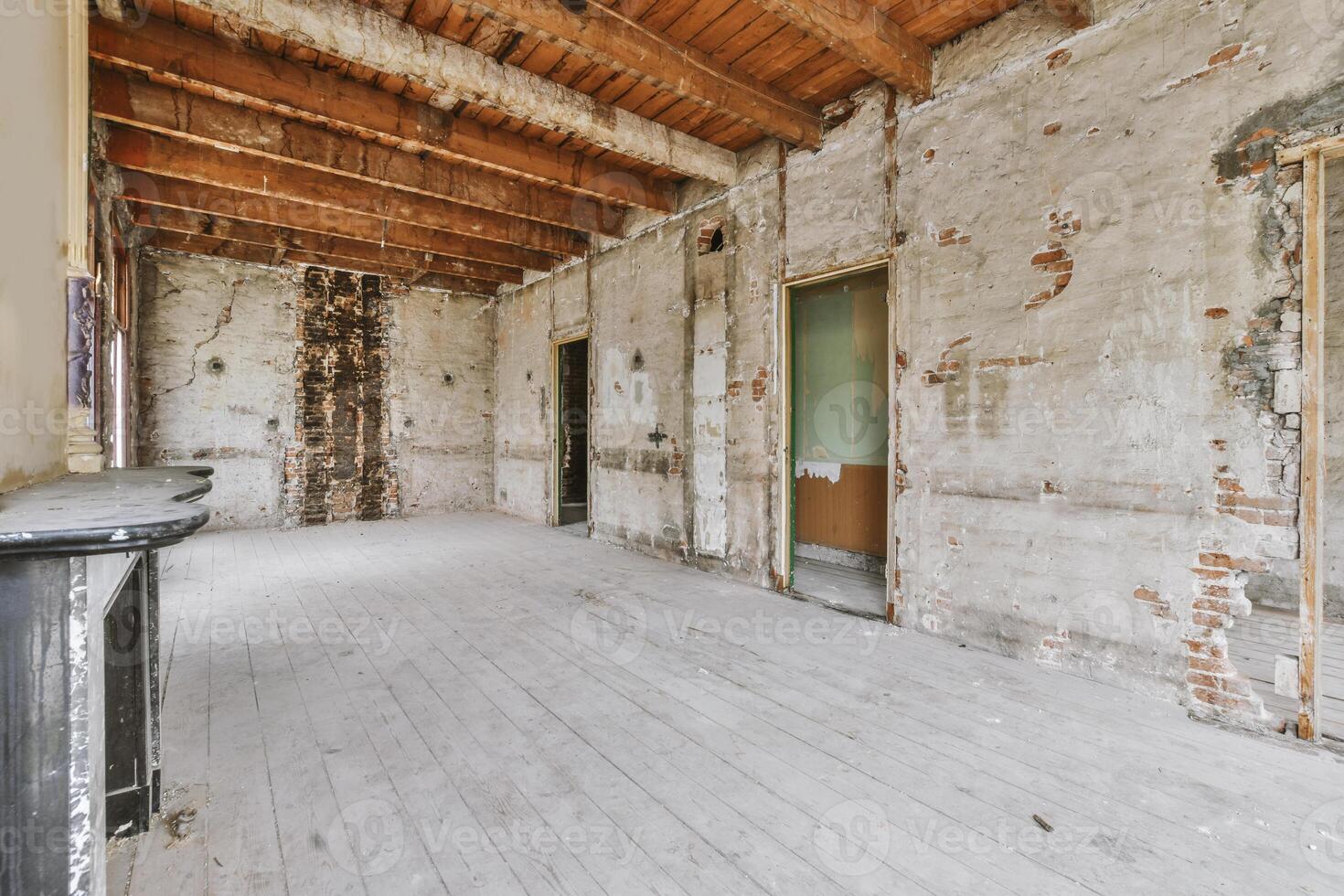 An empty room with wood floors and exposed brick walls photo