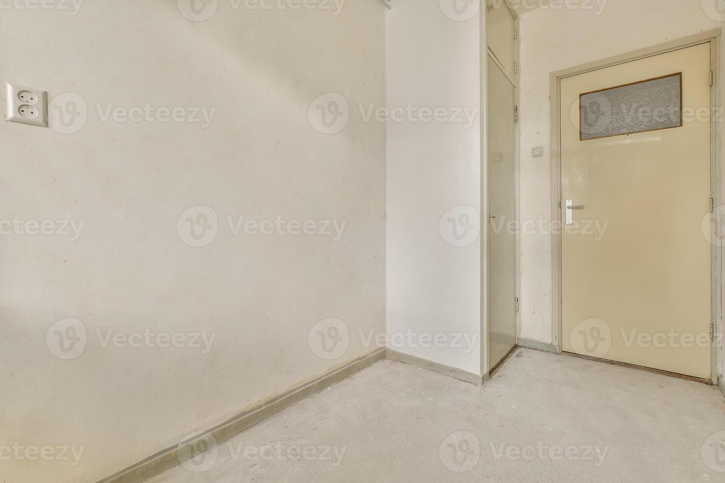 An empty room with a door and a white wall photo