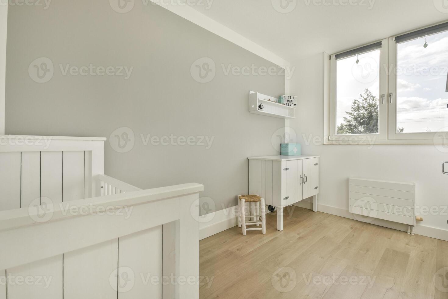 A white room with a crib and a window photo