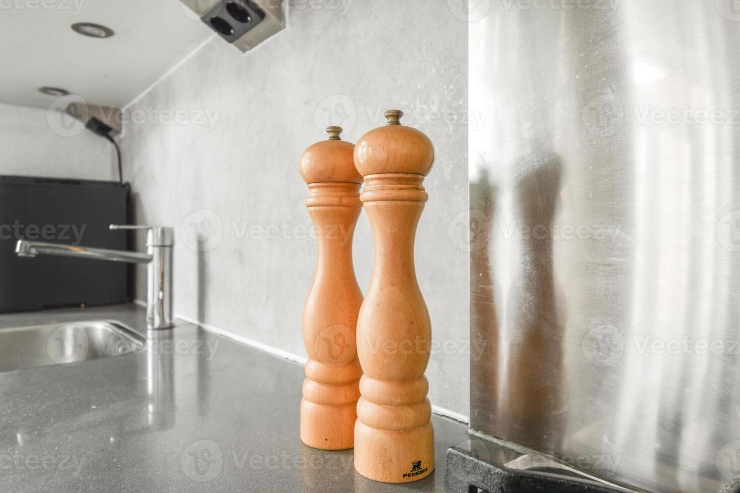 A pair of wooden pepper grinders on a counter photo