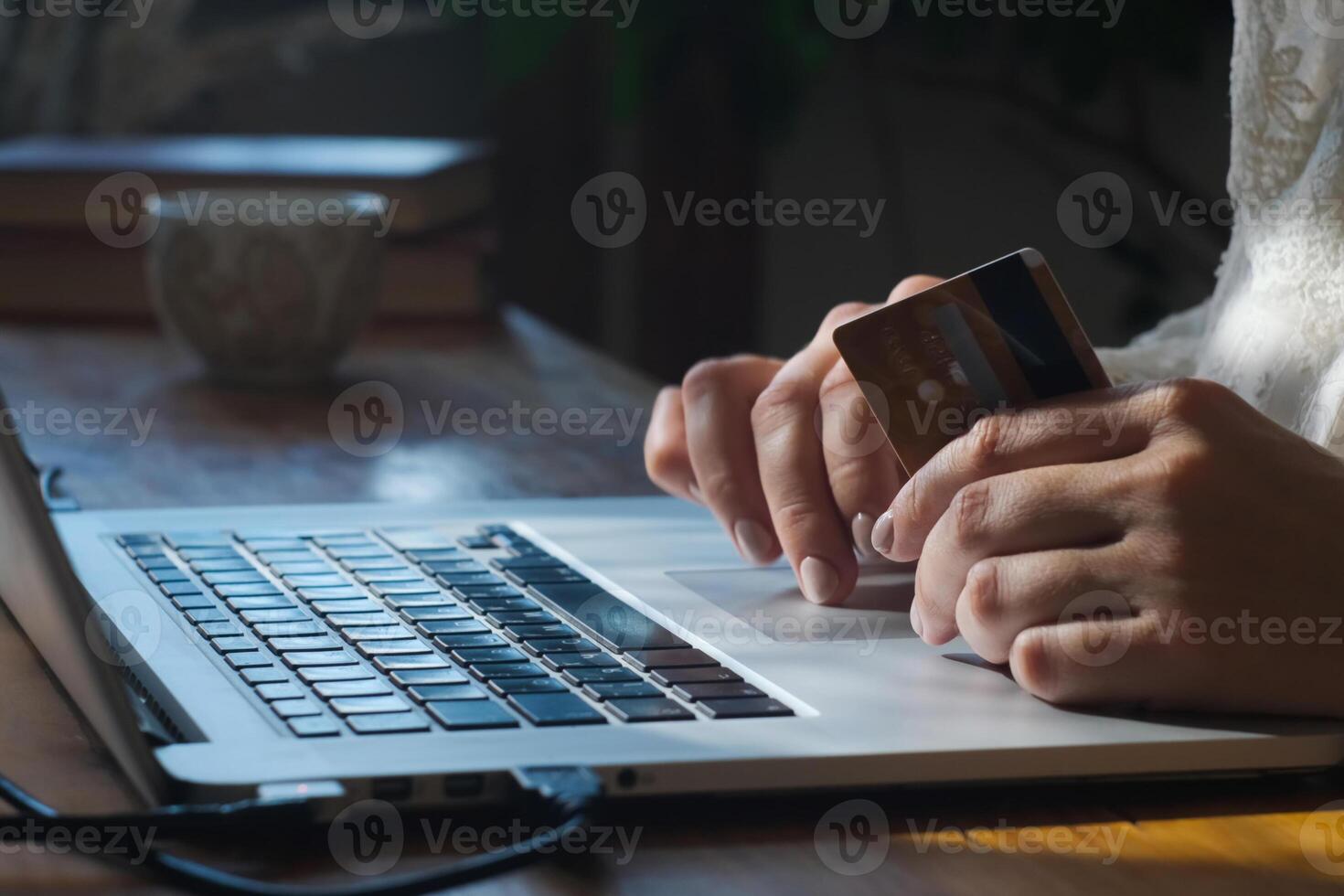 Transfer money online using bank payment card. Hands input credit card data using laptop. photo