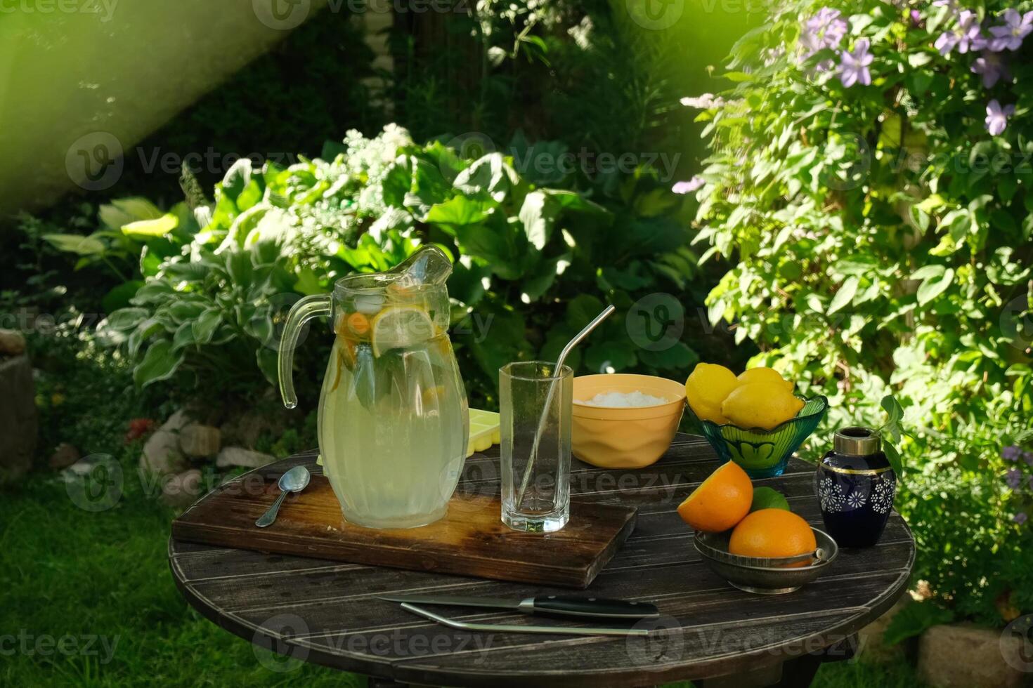 Refreshing summer citrus drink. Ingredients for making lemonade on garden wooden table. photo