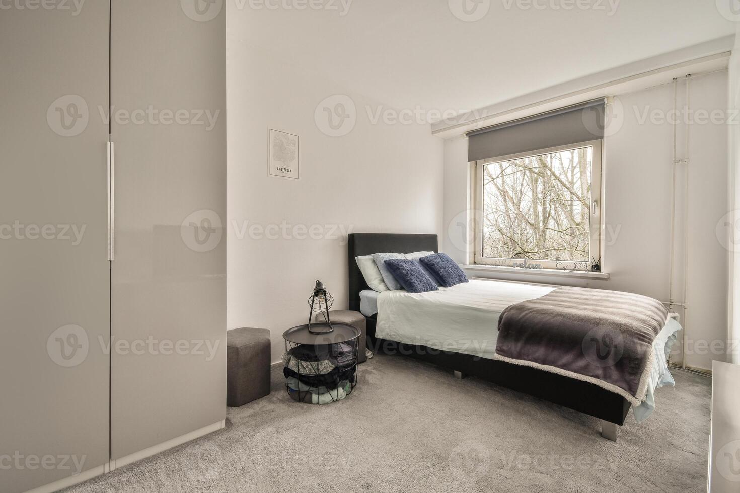 A bedroom with a bed, a chair and a window photo