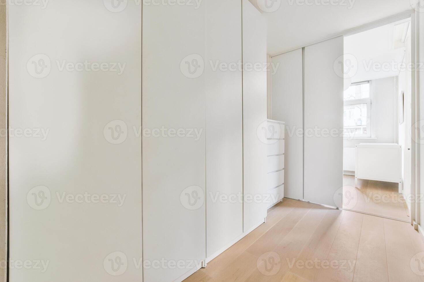 A white closet with wooden floors and white walls photo