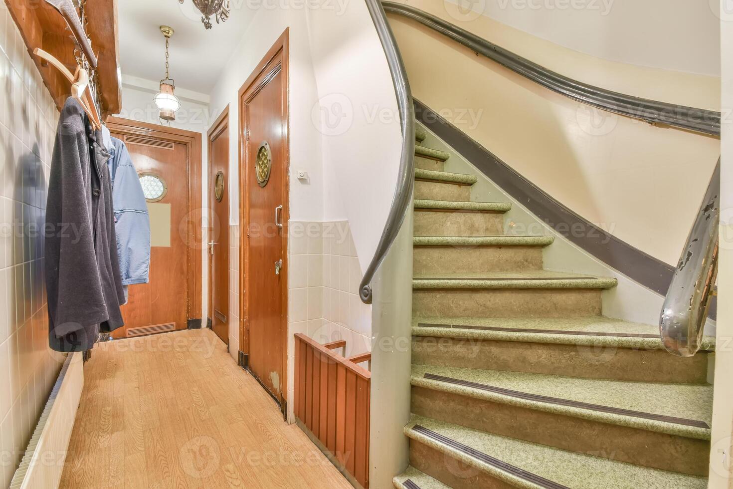 A hallway with a staircase and a coat rack photo