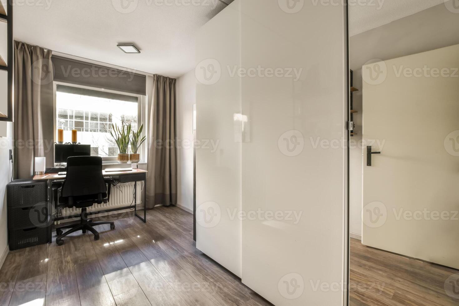 A clean room with a desk and a window photo