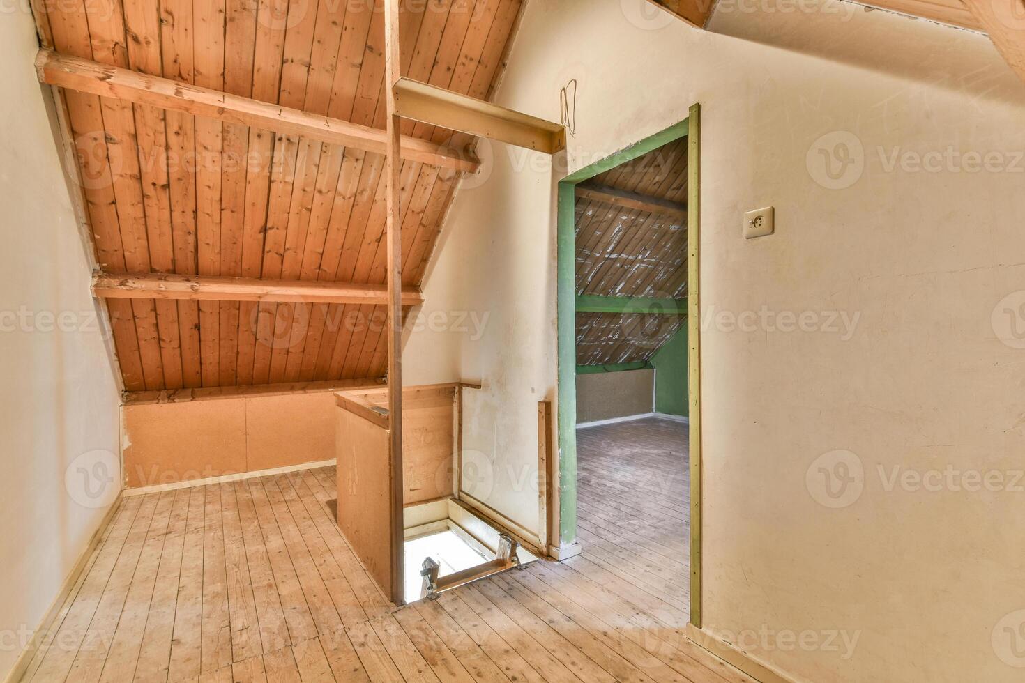 An empty attic with wooden floors and a door photo