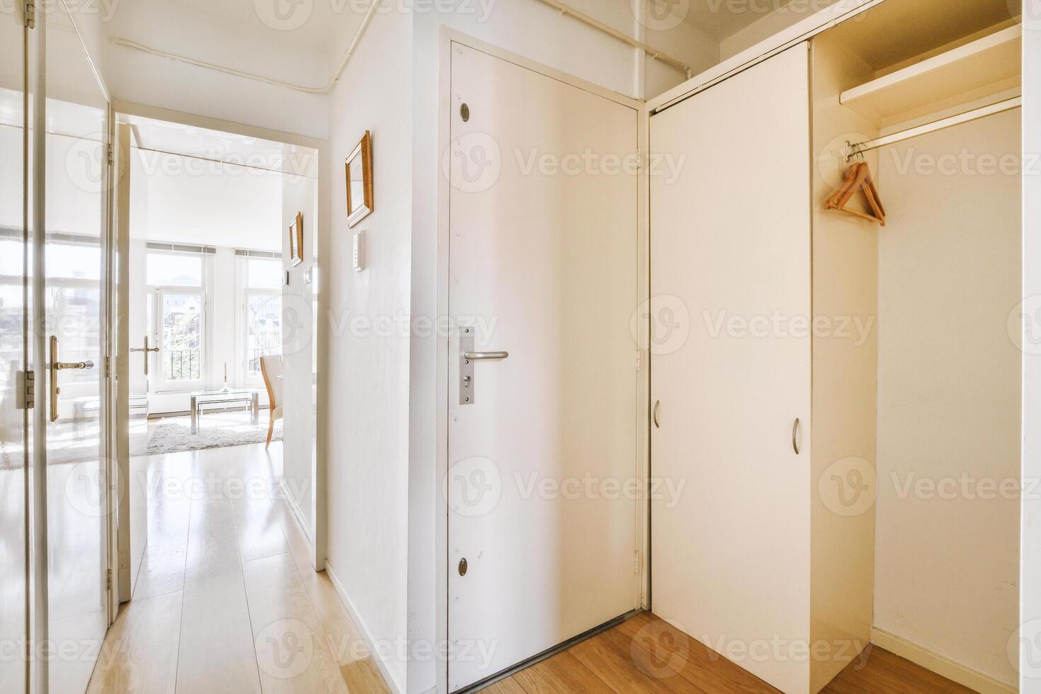 A hallway with a closet and wooden floors photo