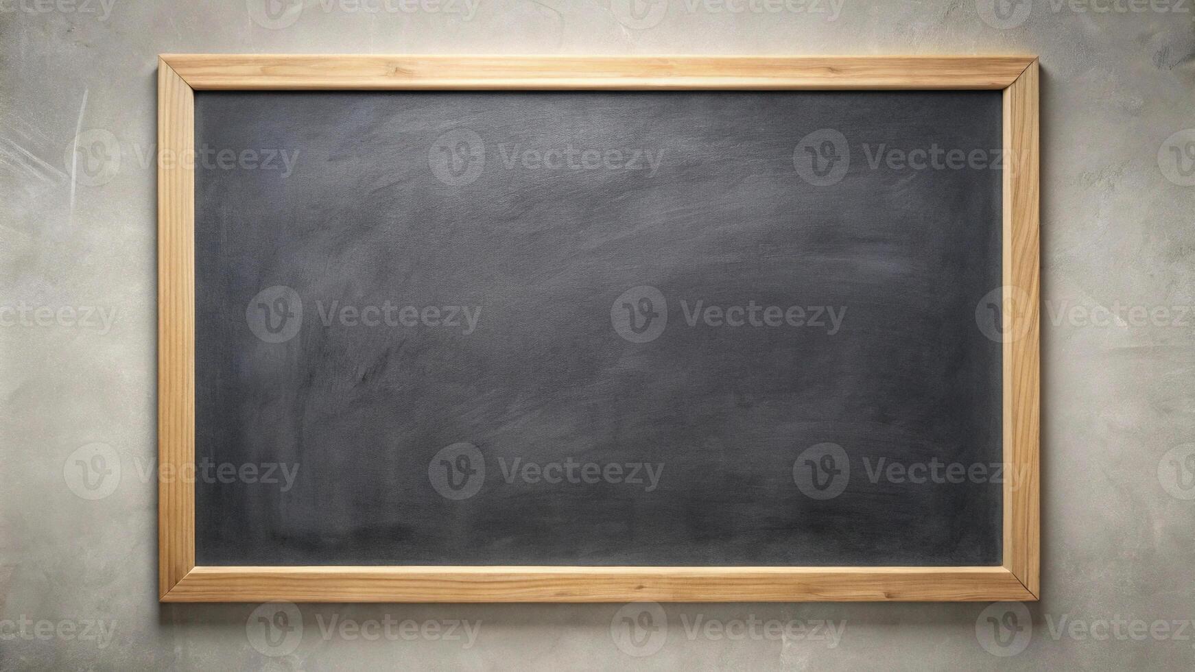 A spotless black chalkboard with wooden border on plain wall photo