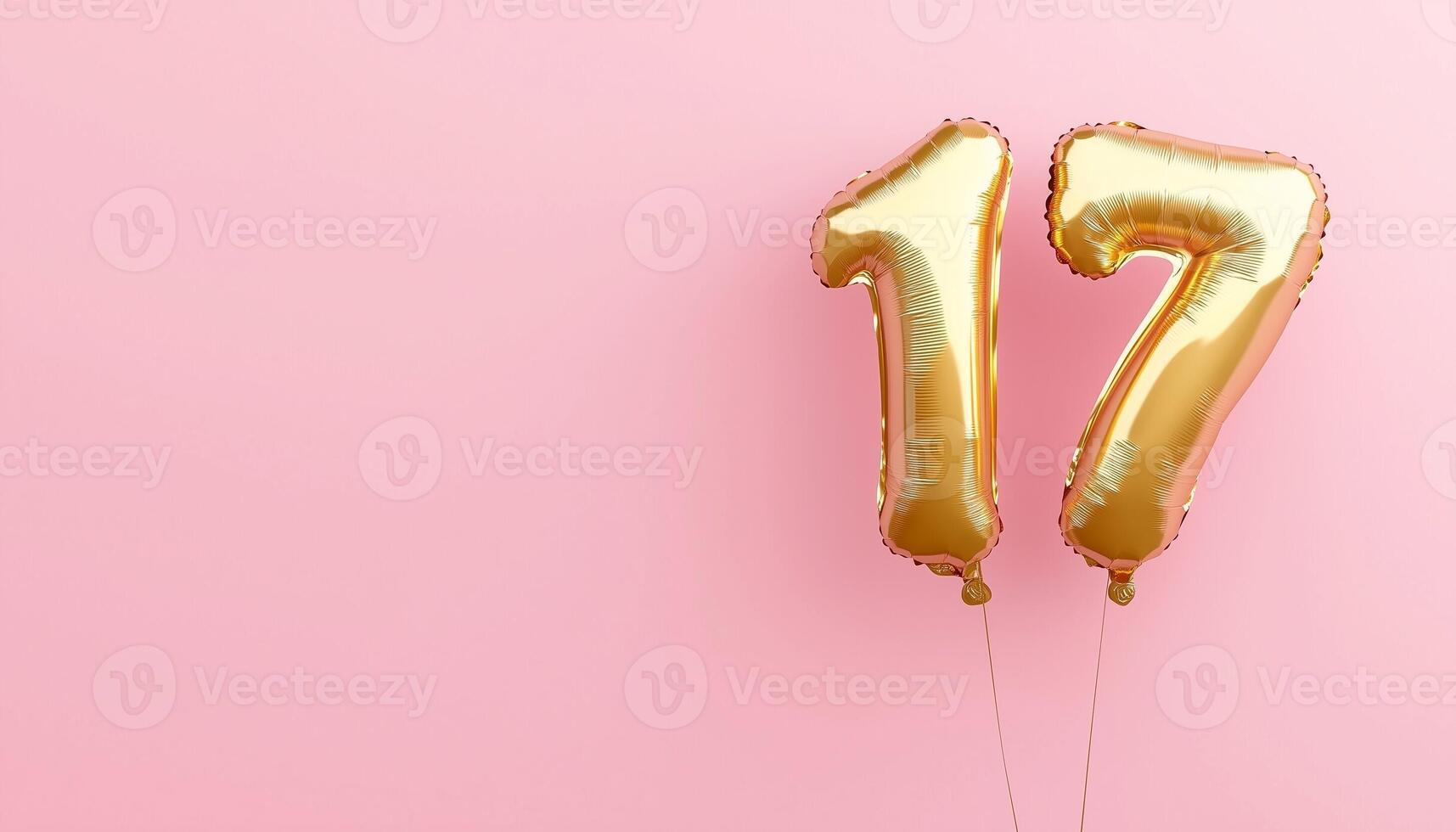 Number 17 metallic gold balloon for celebration card copy space pink solid background photo