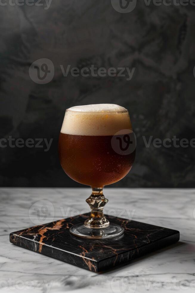 A glass of beer sitting on a marble coaster photo