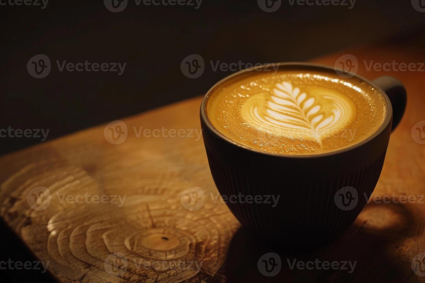 A cup of coffee with a leaf design on top photo