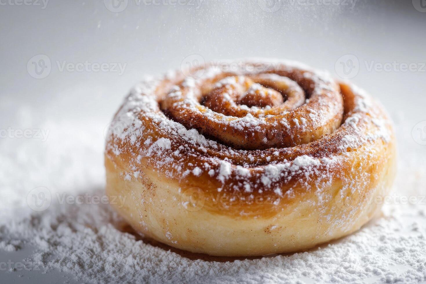 A cinnamon roll covered in powdered sugar photo