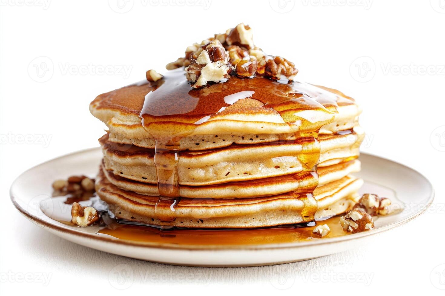 A stack of pancakes with syrup and pecans photo