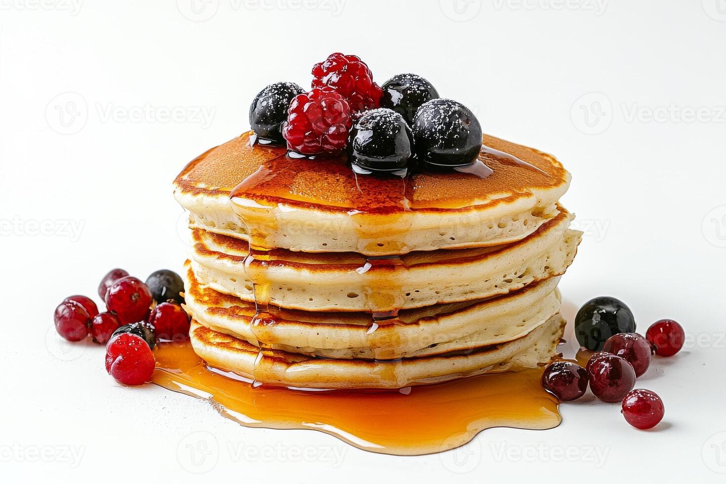 A stack of pancakes with berries and syrup photo