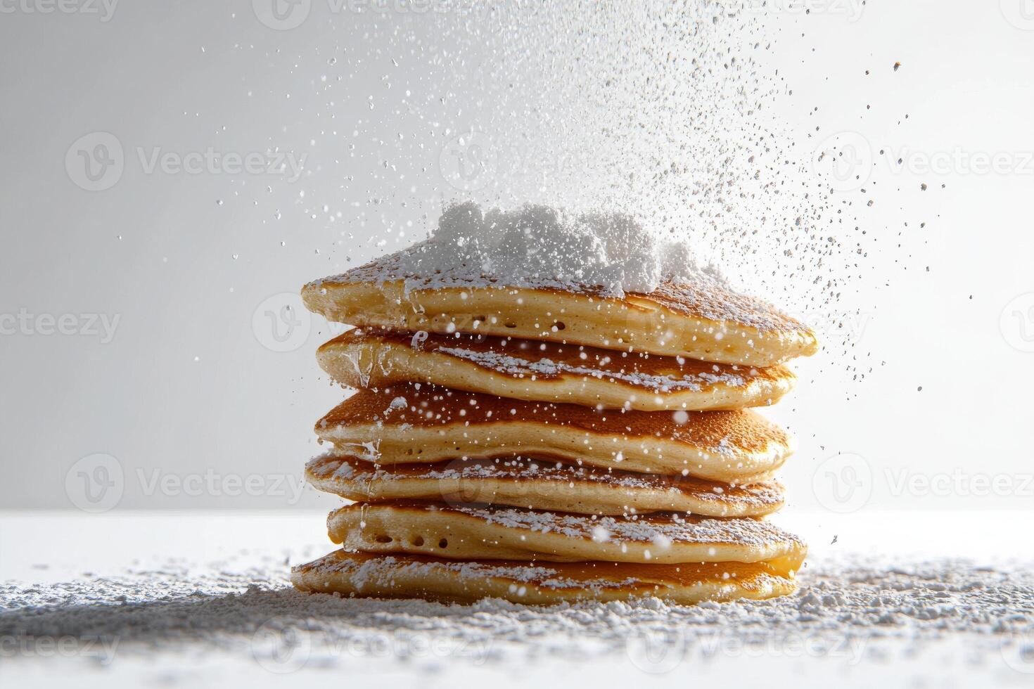 A stack of pancakes with powdered sugar on top photo