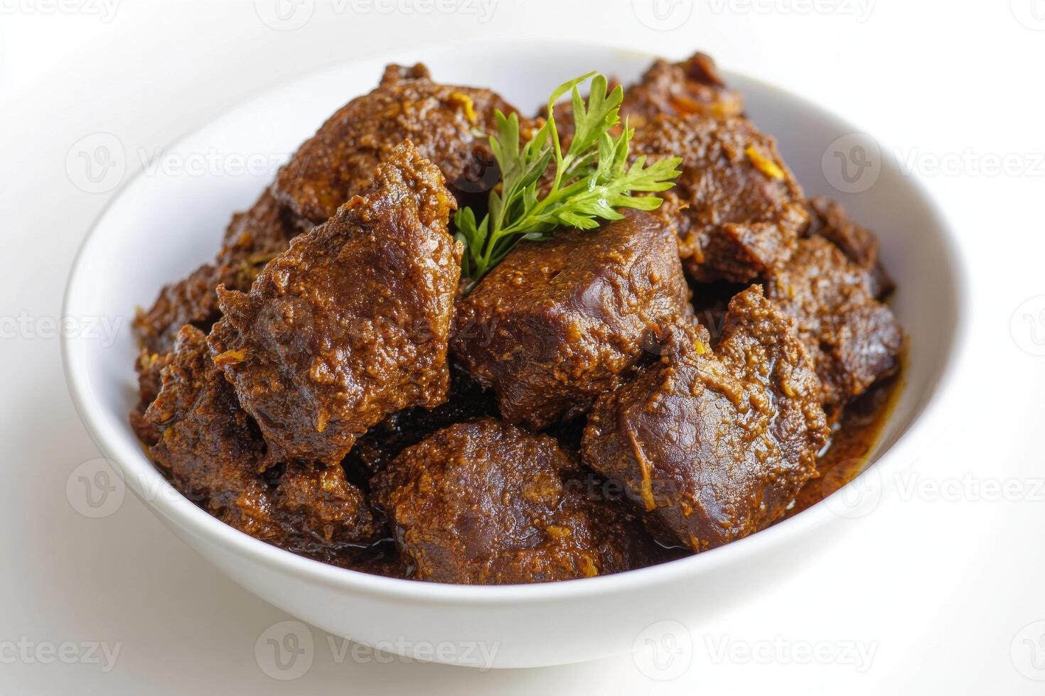 A bowl of beef stew with a sprig of rosemary photo