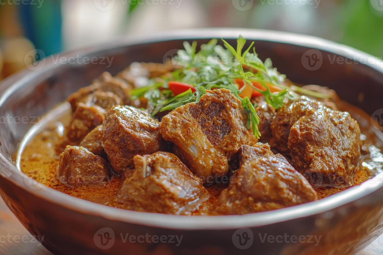 A bowl of meat and vegetables in a curry photo
