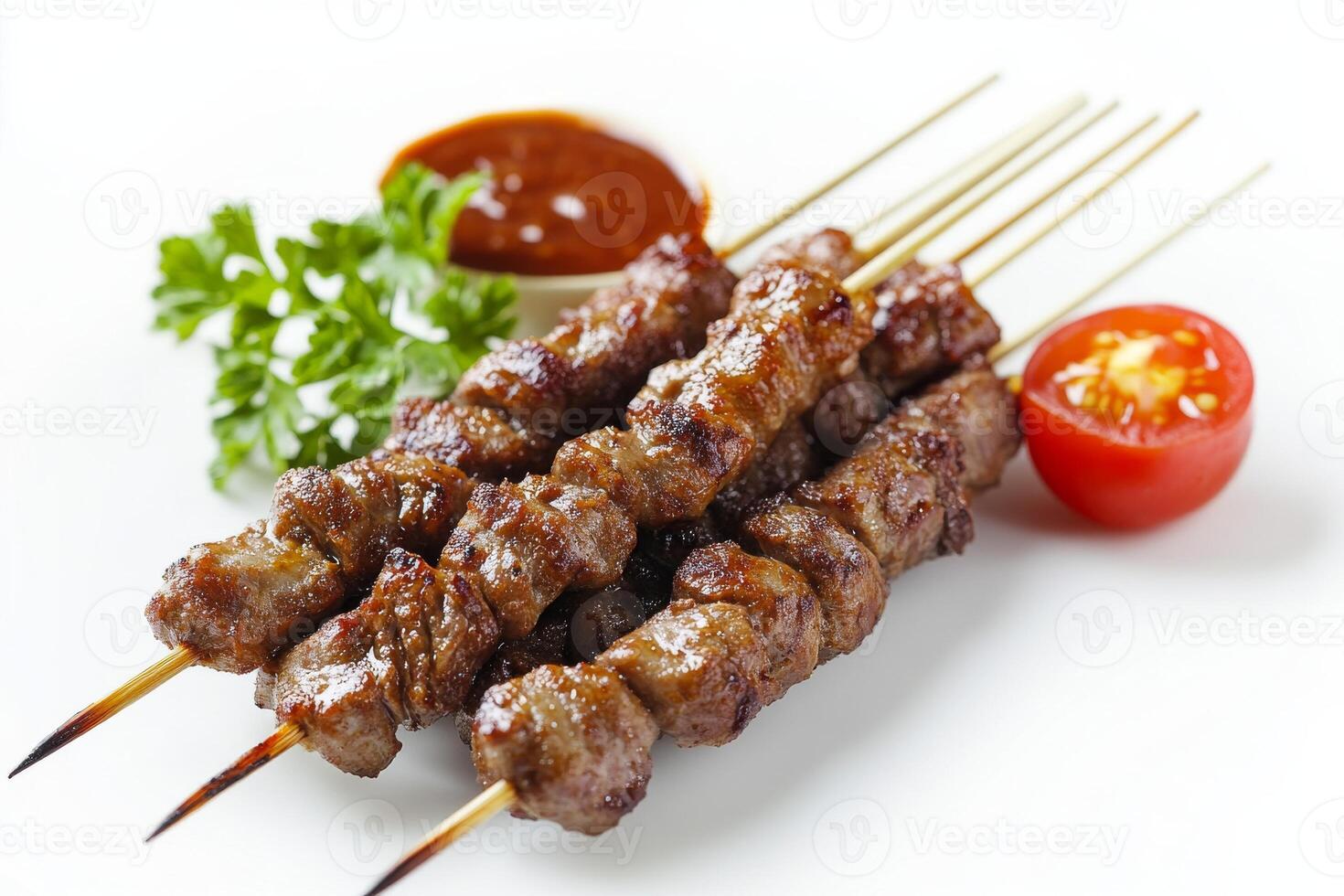 A skewered meat on a white plate with sauce photo