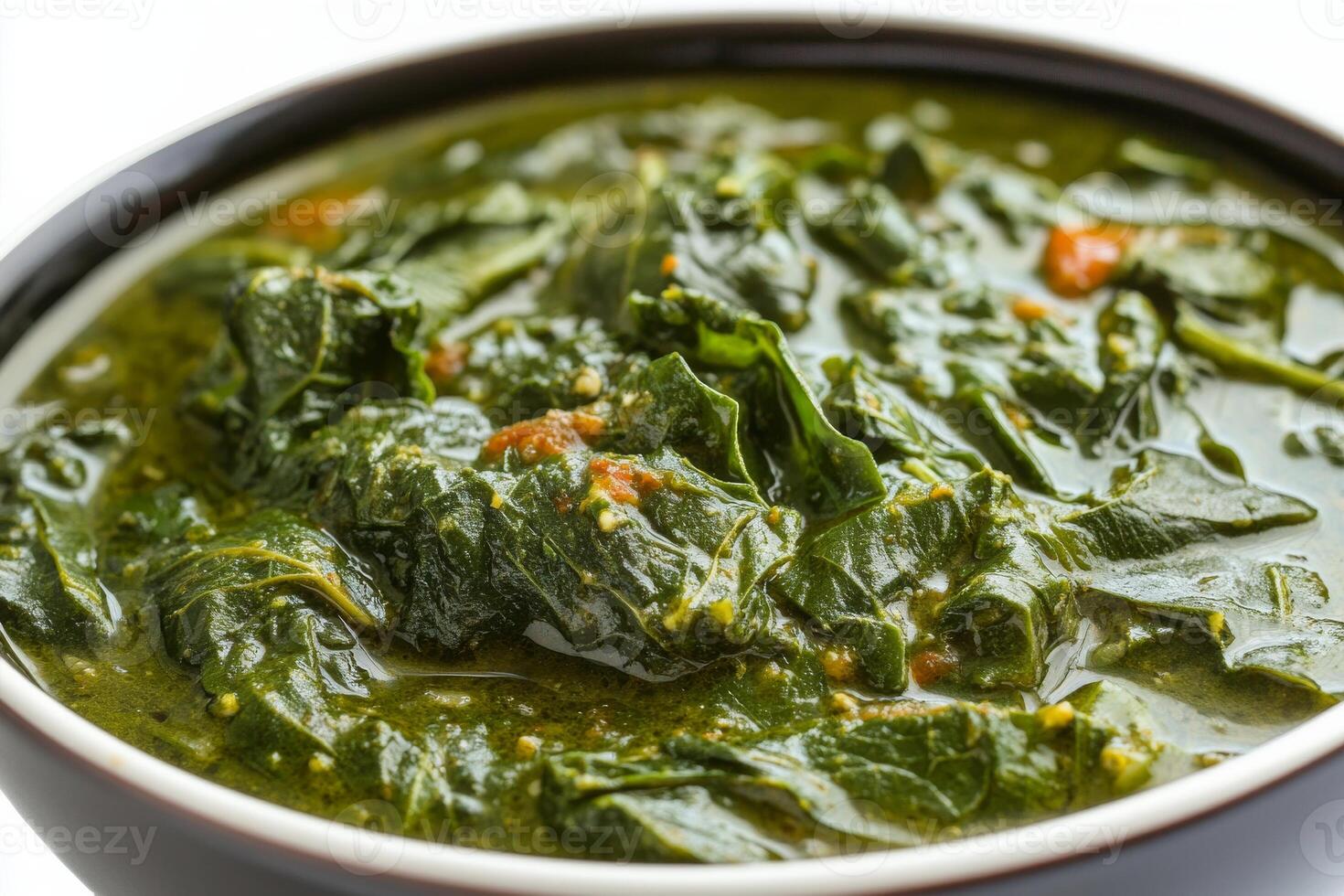 A bowl of spinach with a spoon in it photo