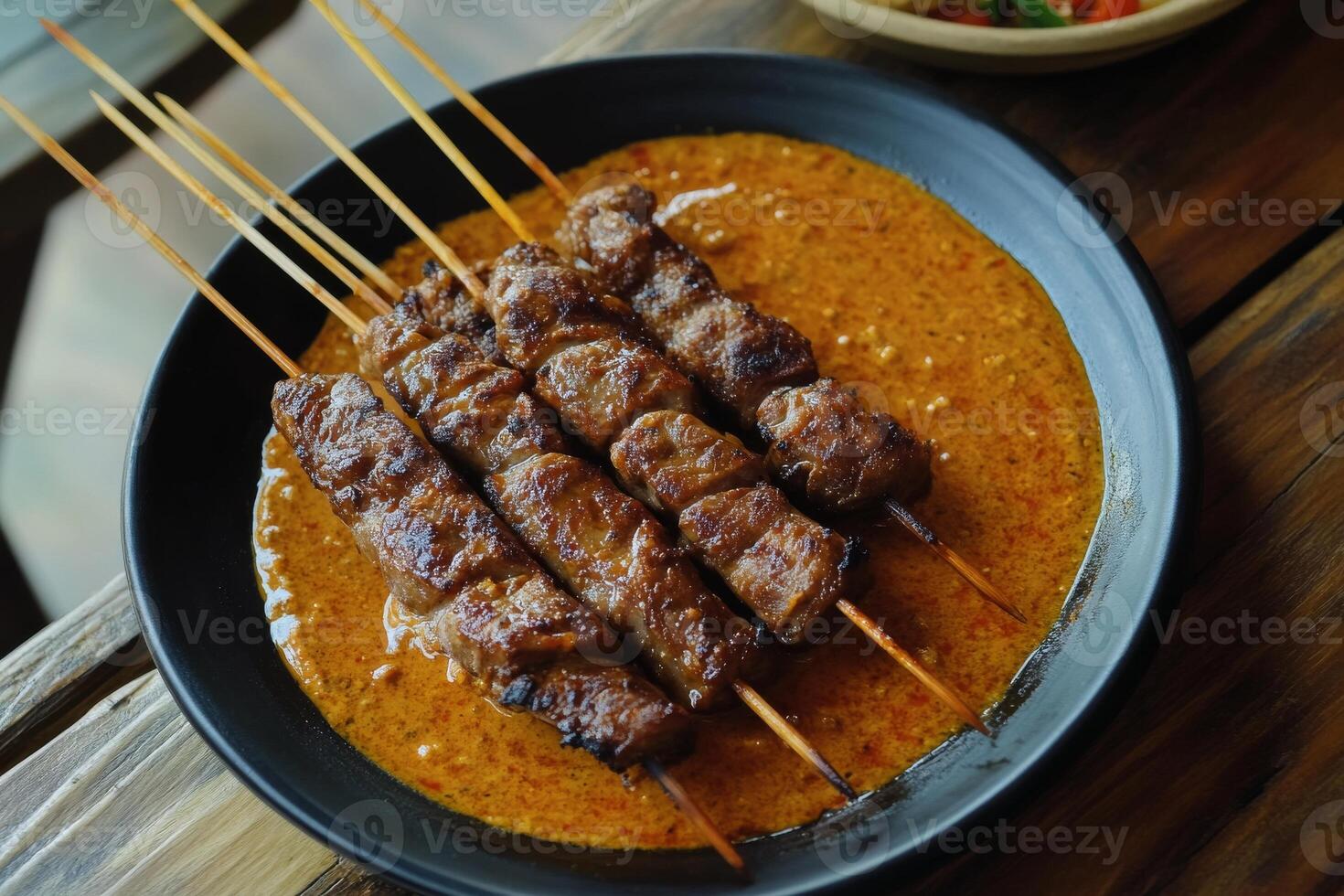 A plate of meat skewers on a wooden table photo