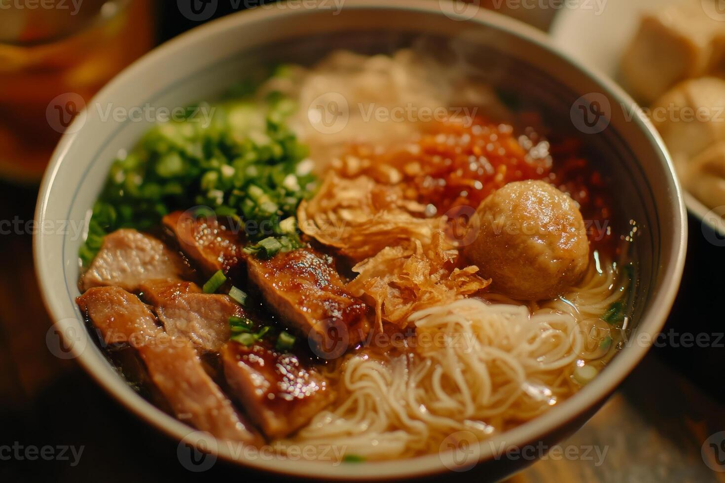 A bowl of noodles with meat and vegetables in it photo