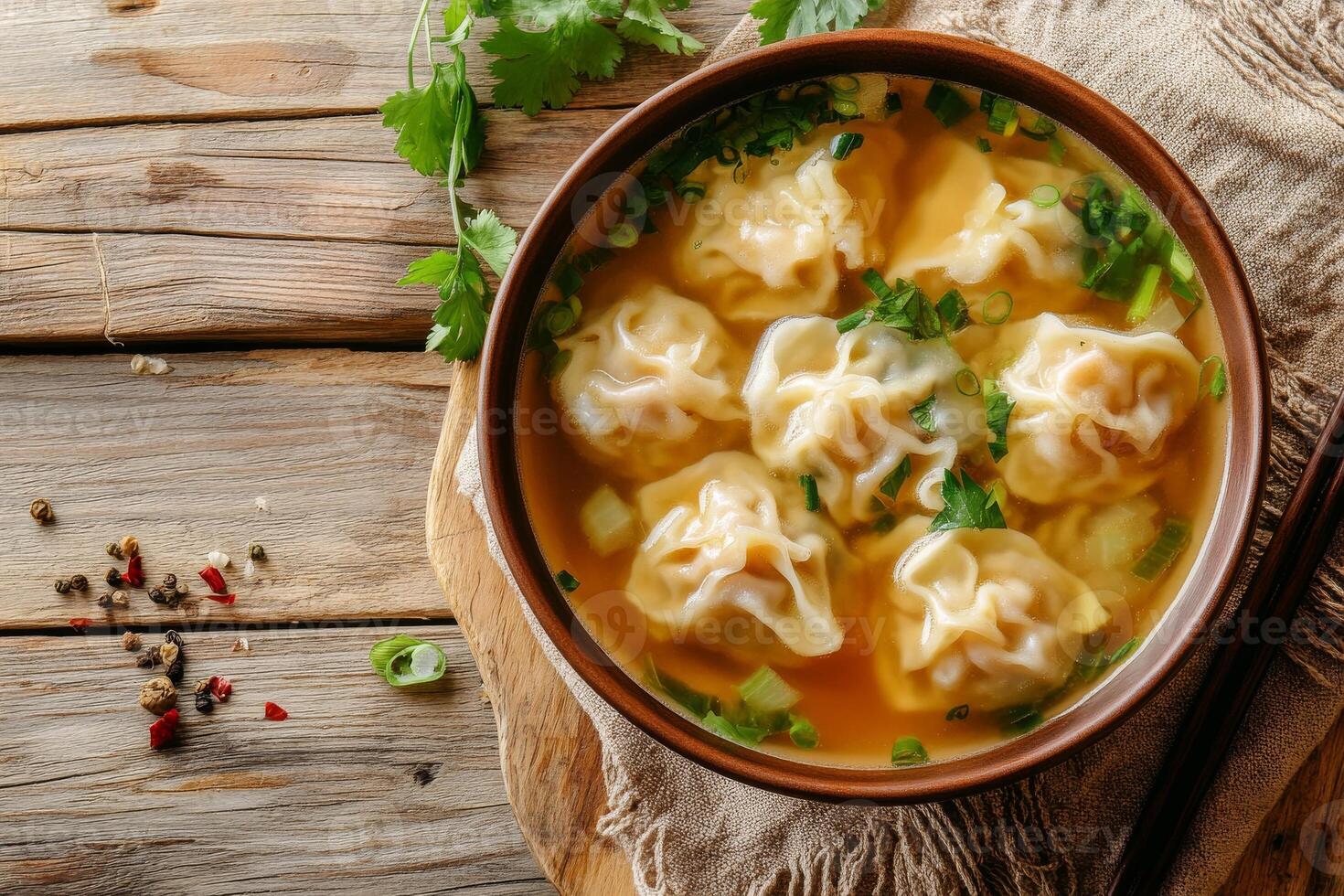 A bowl of soup with dumplings and herbs photo