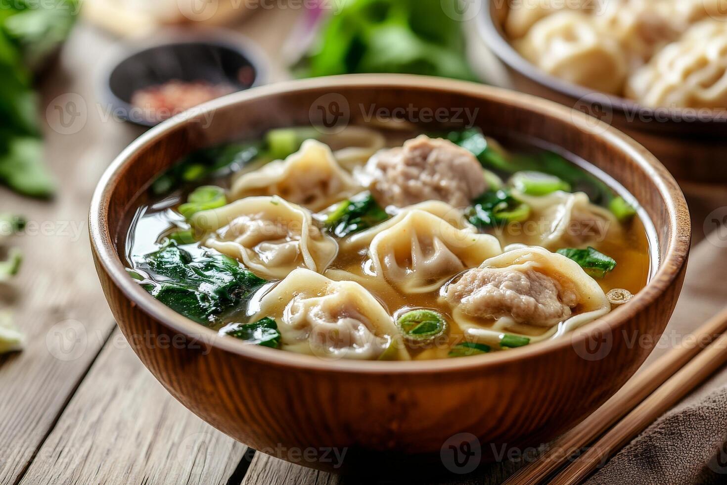 Chinese dumplings in soup with chopsticks photo