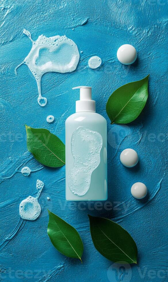A bottle of soap and green leaves on a blue background photo