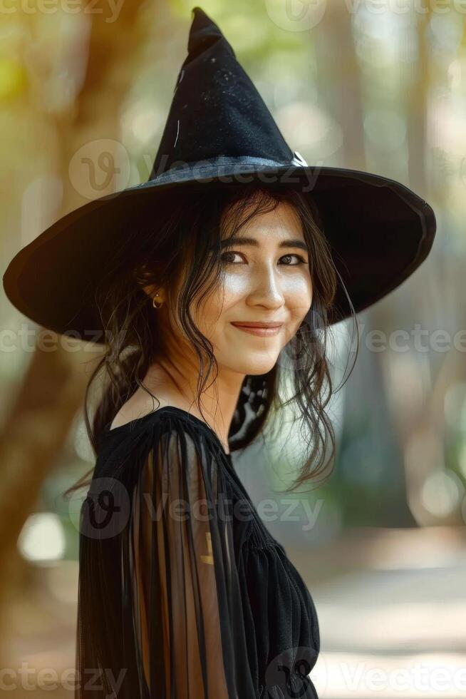 A woman in a black witch hat smiling photo