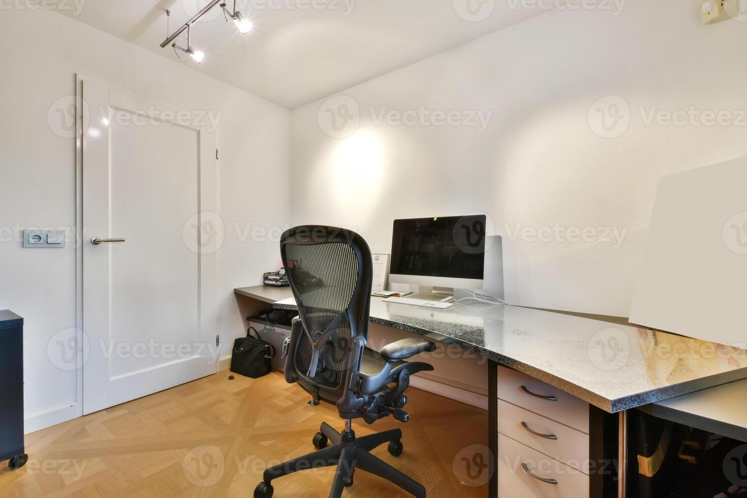 A home office with a desk, computer and chair photo