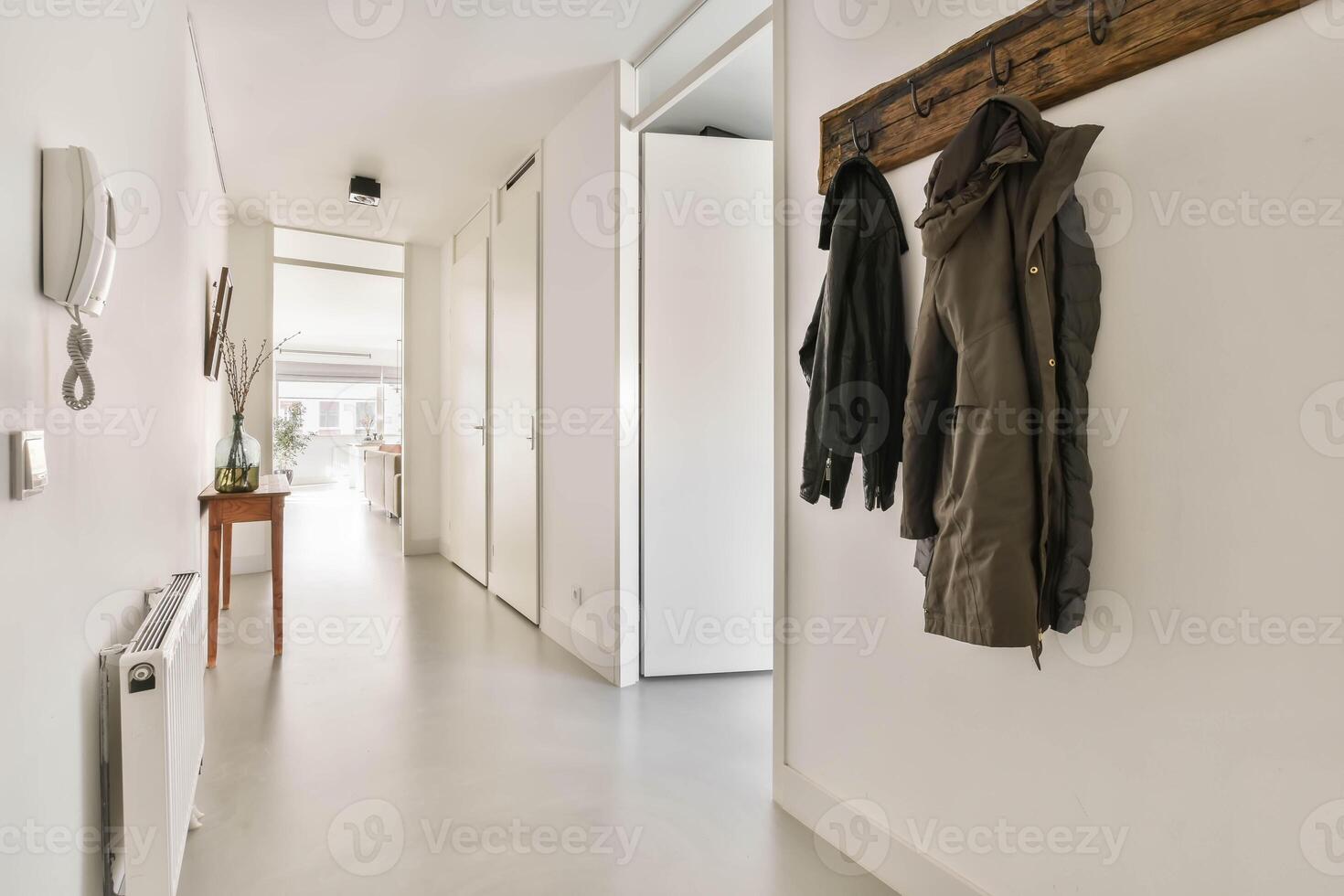 A hallway with a coat rack and a wooden wall photo