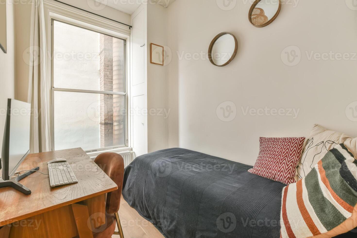 A bedroom with a bed, desk and window photo