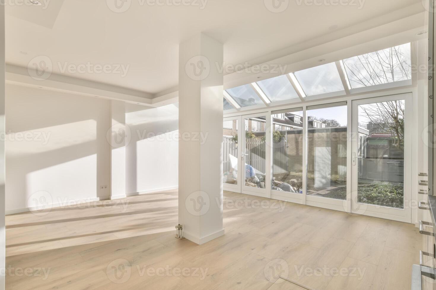 An empty room with a large window and wooden floors photo