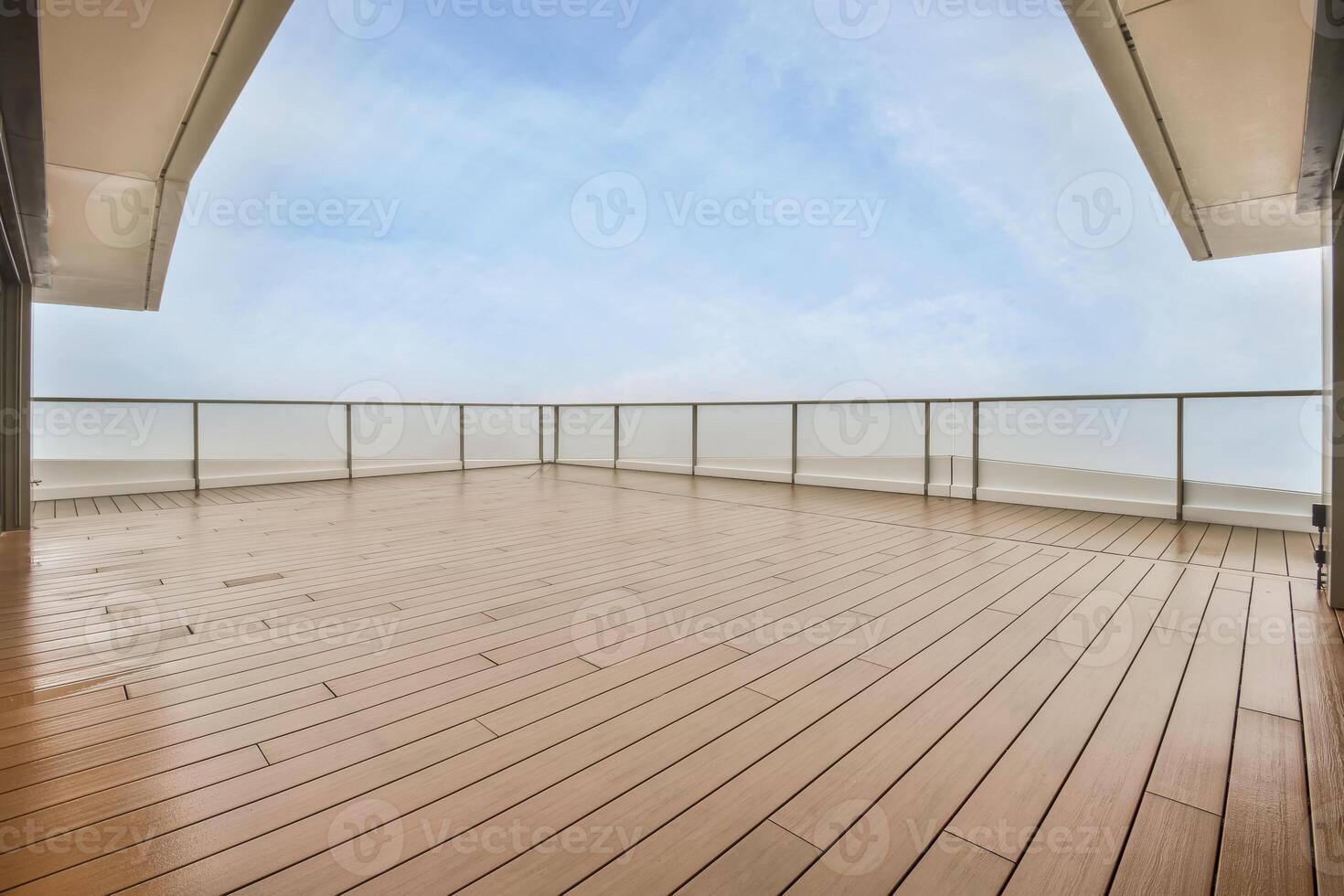 A balcony with wooden flooring and a view of the sky photo