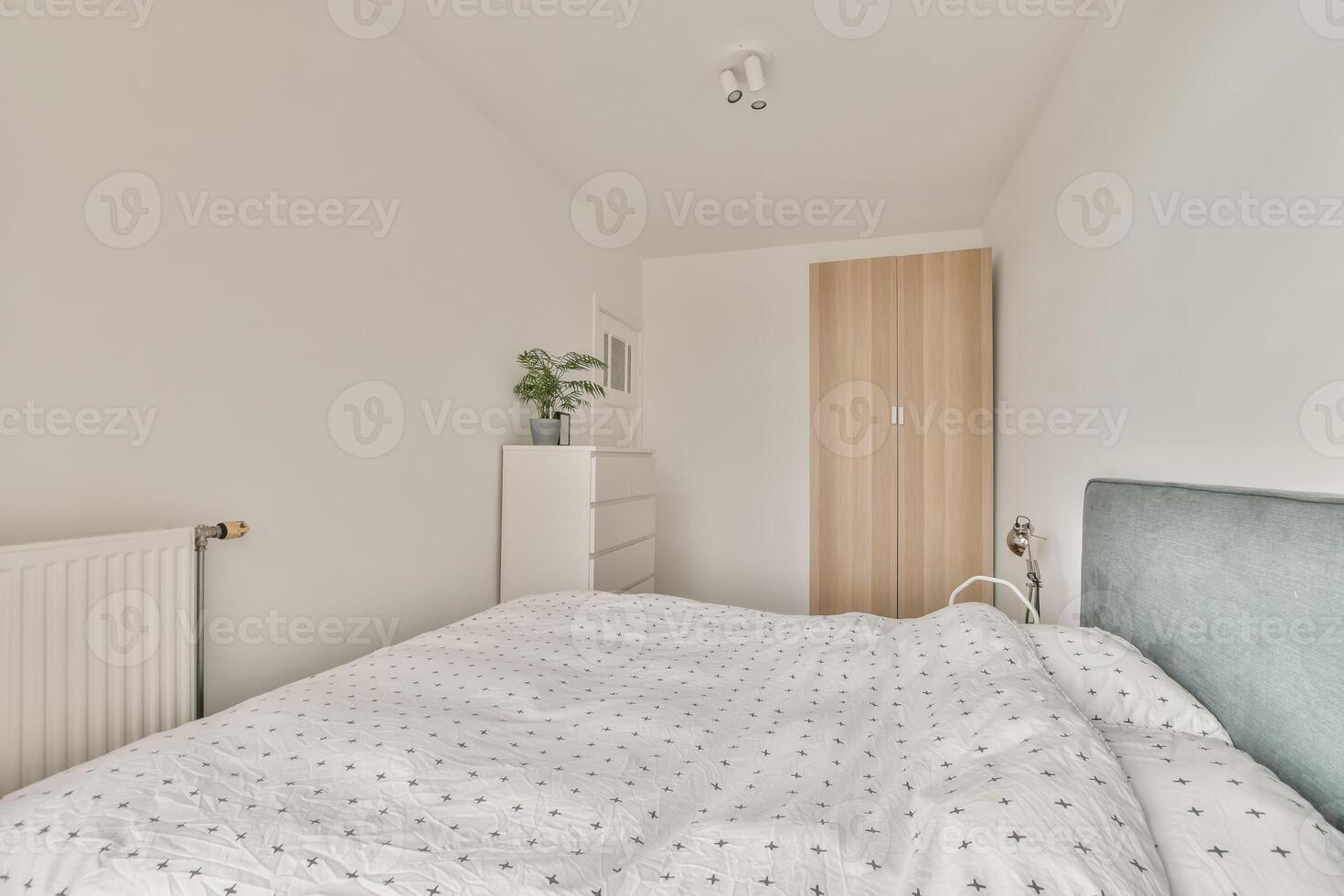 A bedroom with a white bed and a white dresser photo