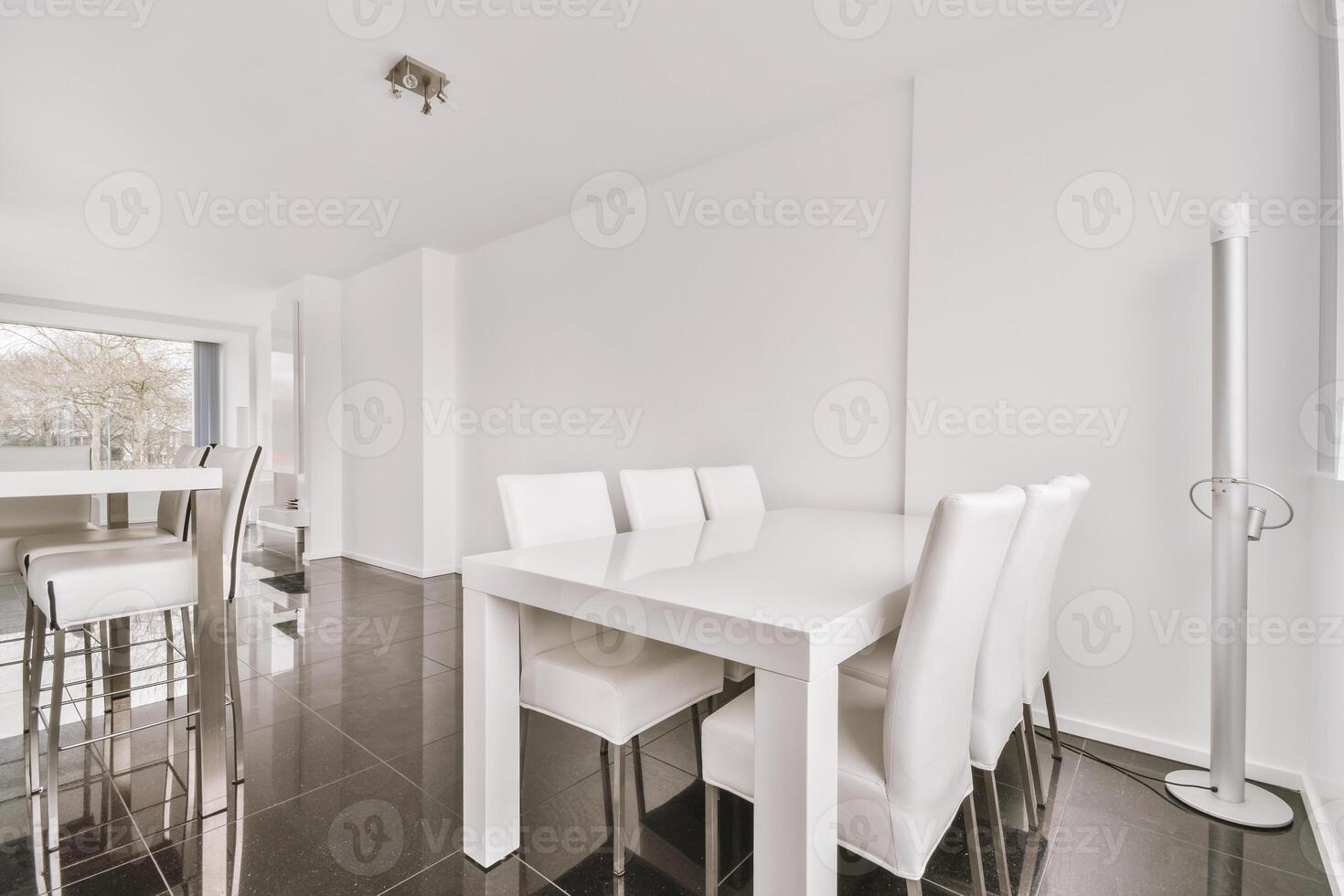 A white dining room with a table and chairs photo