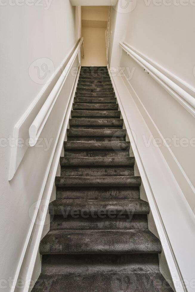 A staircase with black carpet and white railings photo