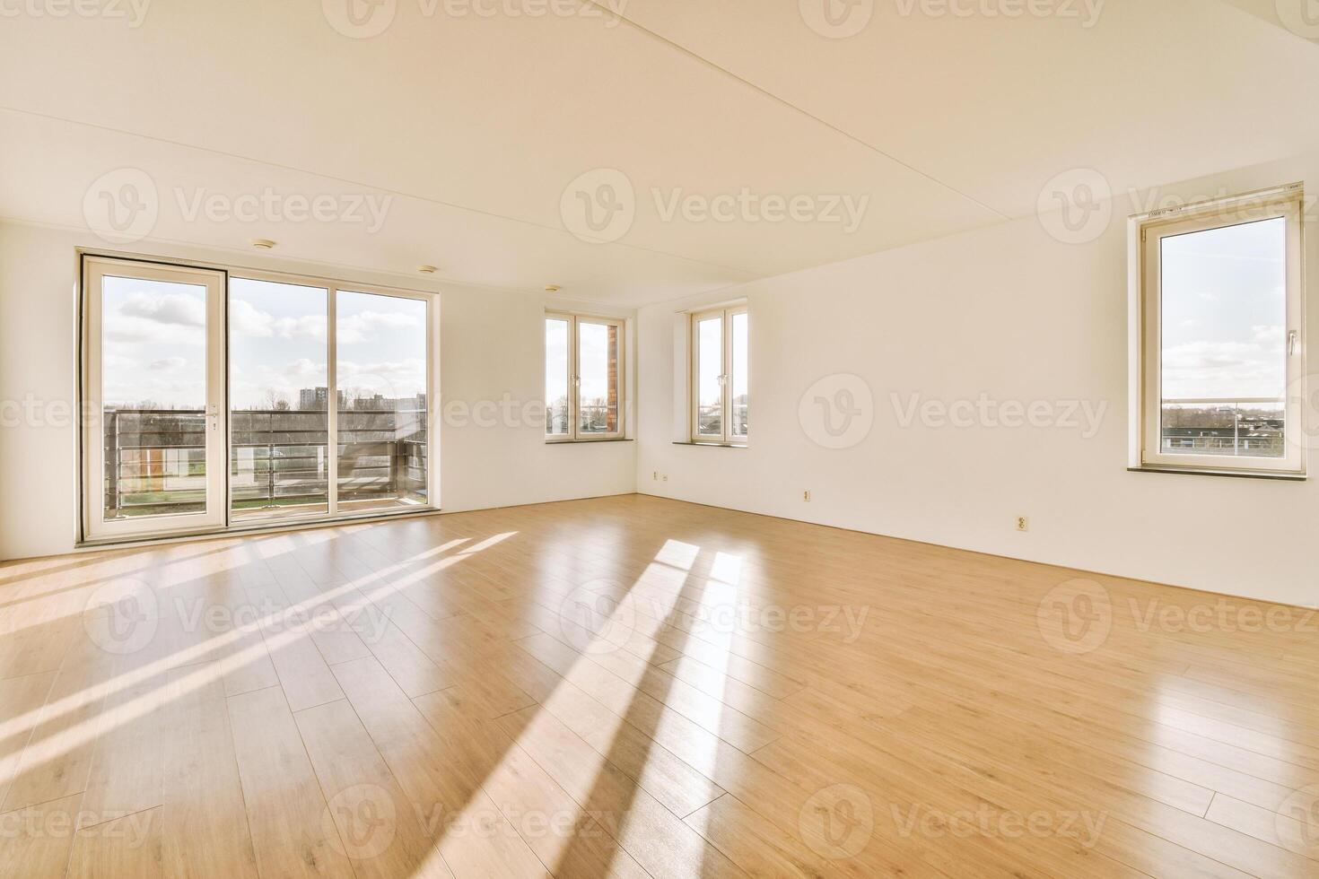 An empty room with hardwood floors and large windows photo