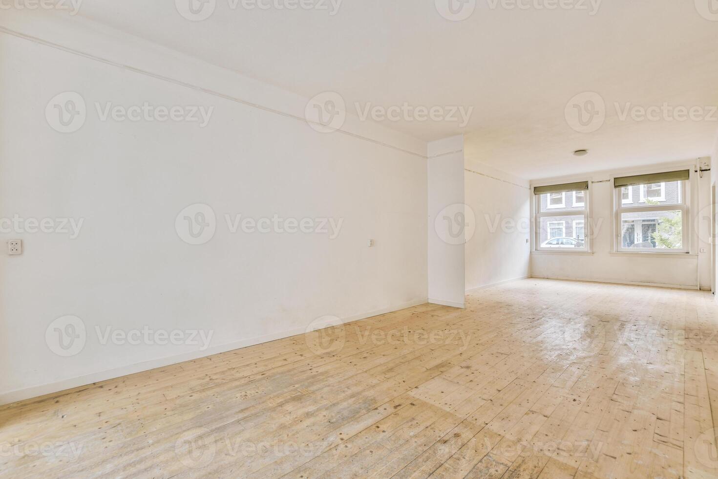 An empty room with wooden floors and white walls photo