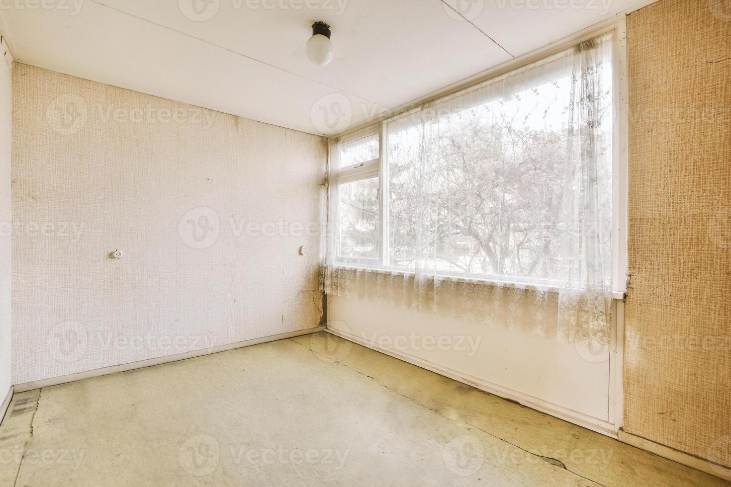 An empty room with a window and a floor photo