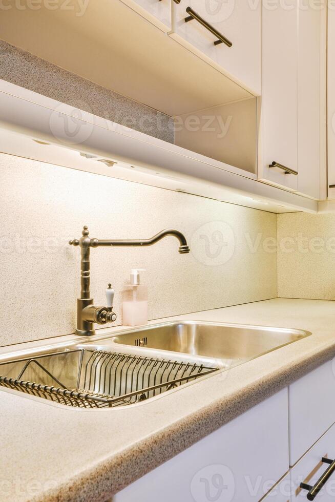 A kitchen with a sink and a counter photo