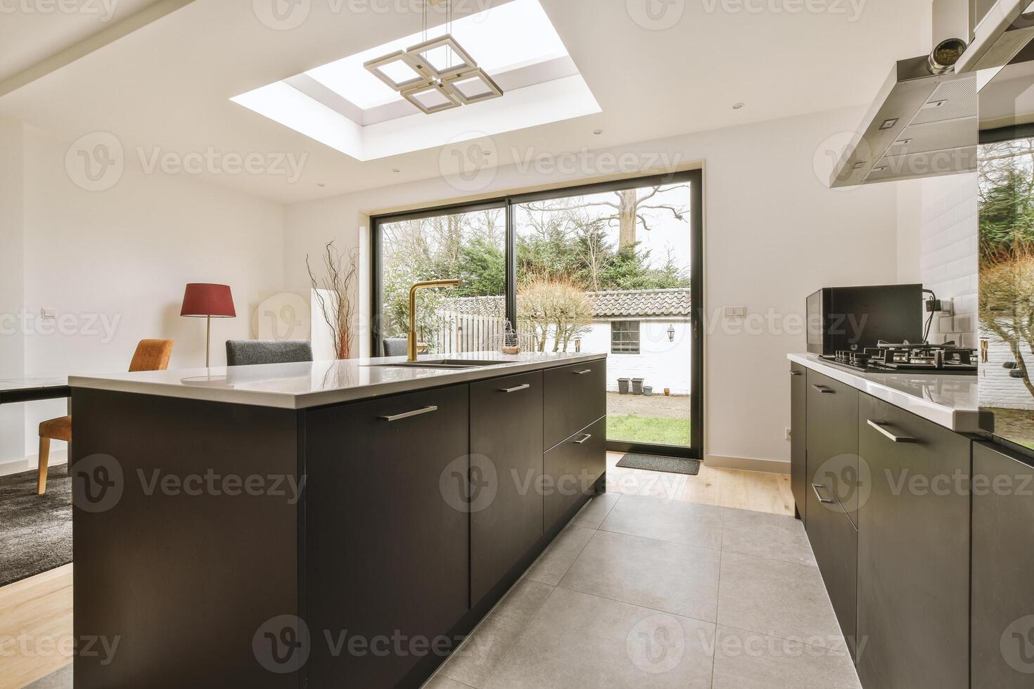 A kitchen with a skylight and a table photo