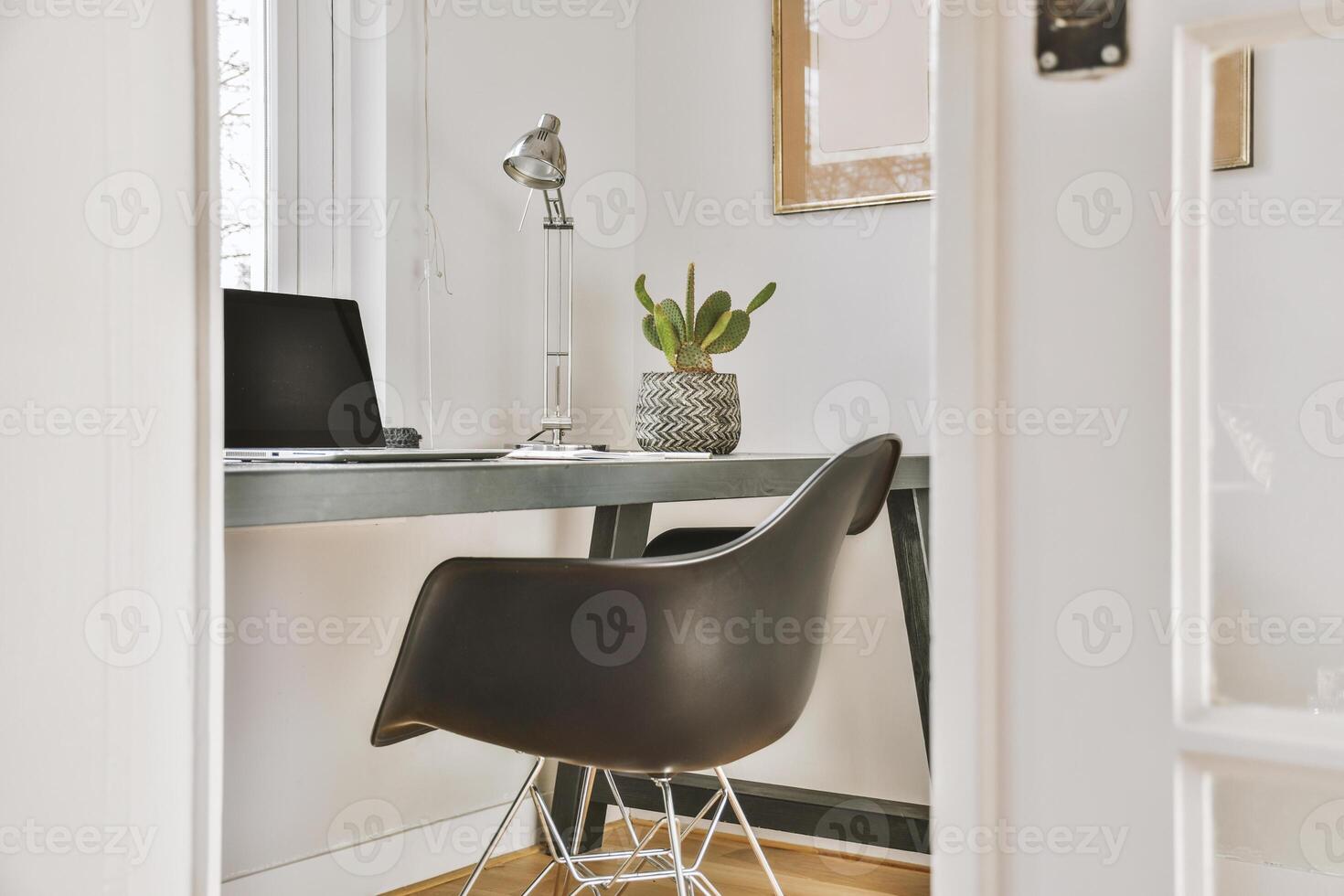 A black chair sits in front of a desk photo